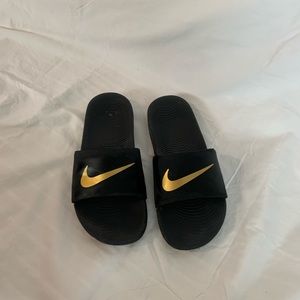 black and gold nike slides in a size 8